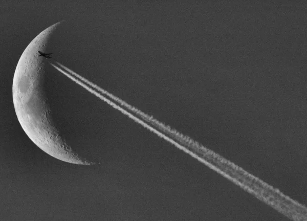 The moment of an airplane passing by in the direction of the moon.