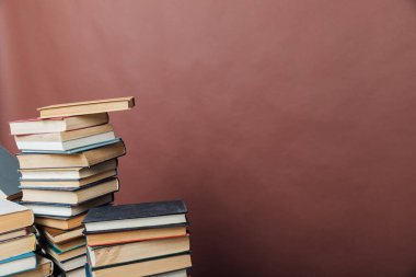Üniversite kütüphanesinde kahverengi arkaplan bilgisi öğretmek için kitap yığınları