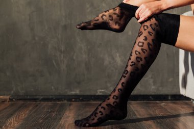 Bir kadın ince ve güzel bacaklara siyah tayt giyer.