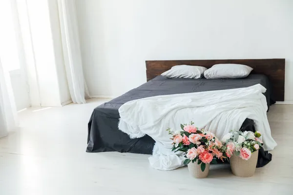 Інтер'єр білої спальні з ліжком і рослинами з квітами — стокове фото