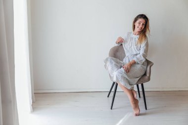 Gri bir sandalyede oturan güzel kadın ev portresi