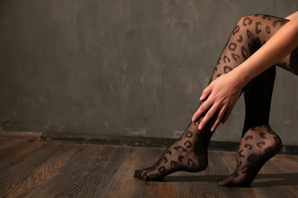 Schöne schlanke Frauenbeine in schwarzen Strumpfhosen als Hintergrund — Stockfoto