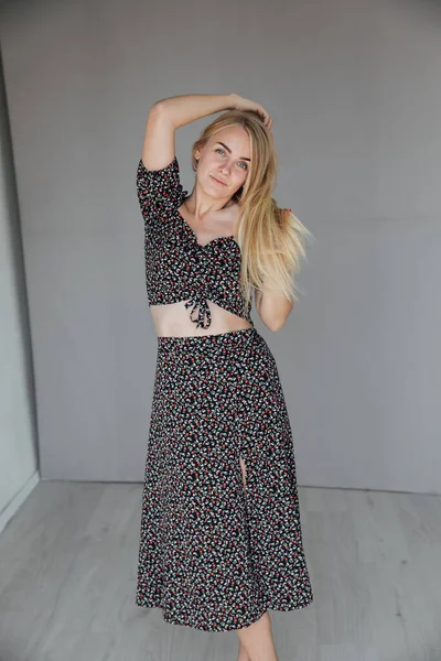 Schöne blonde Frau in einem grauen Kleid — Stockfoto
