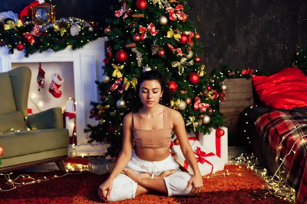 Рождественская йога гимнастика у елки с подарками Новый год — стоковое фото
