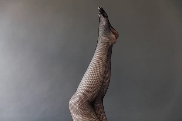 Belas mulheres pernas delgadas em collants em um fundo leve — Fotografia de Stock