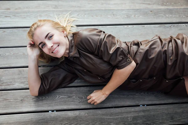Красивая блондинка в платье лежит на досках — стоковое фото