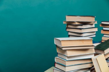 Üniversite kütüphanesinde yeşil arkaplan üzerine kitap yığınları