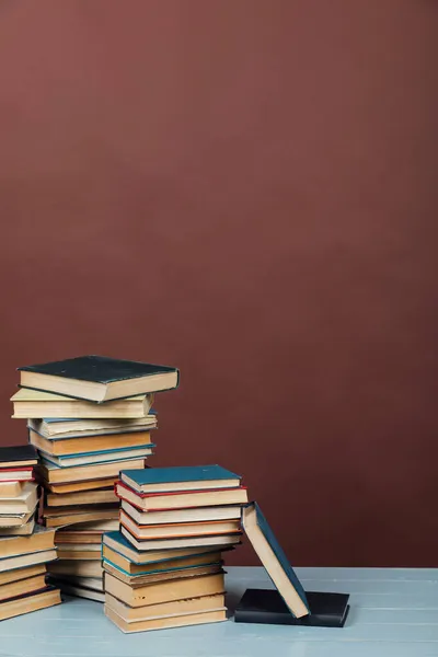 Pile di libri didattici in biblioteca su sfondo marrone — Foto Stock