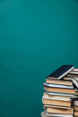 Üniversite kütüphanesinde yeşil arkaplan üzerine kitap yığınları