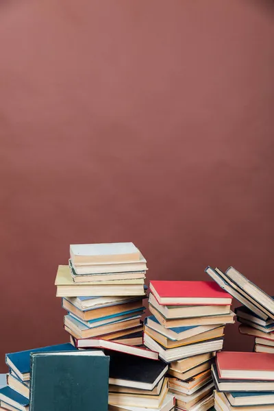 Stapel von Lehrbüchern in der Bibliothek auf braunem Hintergrund — Stockfoto