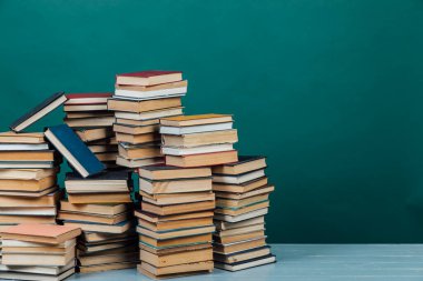 Üniversite kütüphanesinde yeşil arkaplan üzerine kitap yığınları