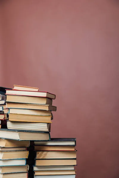 Stapel von Lehrbüchern in der Bibliothek auf braunem Hintergrund — Stockfoto