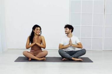 Bir erkek ve bir kadın çift olarak jimnastik yogası yapıyorlar.