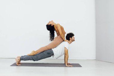 Bir kadın ve bir erkek çift olarak jimnastik yoga yapıyorlar.