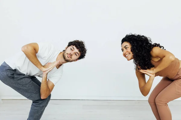 Een vrouw en een man oefenen een gepaarde yoga asana in een witte kamer — Stockfoto