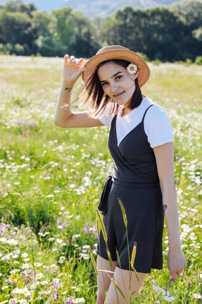 穿着裙子和雏菊穿过田野的女人 — 图库照片