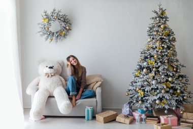 Noel ağacında beyaz bir ayıyla güzel bir kadın.