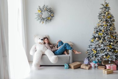 Noel ağacında beyaz bir ayıyla güzel bir kadın.