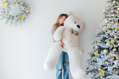 Noel ağacında beyaz bir ayıyla güzel bir kadın.