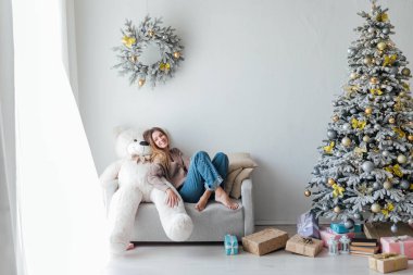 Noel ağacında beyaz bir ayıyla güzel bir kadın.