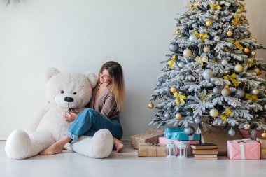 Noel ağacında beyaz bir ayıyla güzel bir kadın.