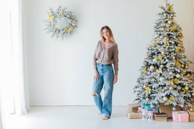 Beyaz Noel ağacı süslemesinde güzel bir kadın. Yeni yıl hediyeleri.