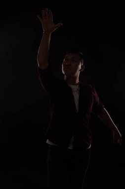 Asyalı bir adam diskoda karanlıkta müzikle dans ediyor.