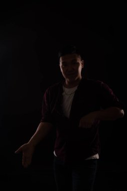 Asyalı bir adam diskoda karanlıkta müzikle dans ediyor.