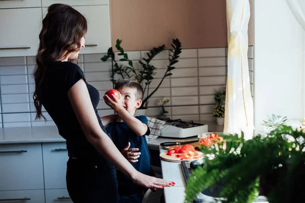 Мать и сын готовят свежие овощи для салата на обед на кухне — стоковое фото