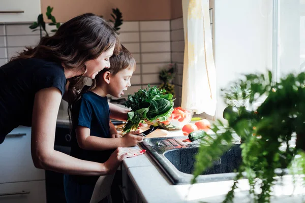 Mutter und Sohn bereiten mittags in der Küche frisches Gemüse für den Salat zu — Stockfoto