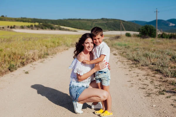 Mère étreint son fils lors d'une promenade dans le champ — Photo