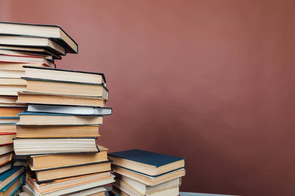 Viele Bücher zum Lernen in der Universitätsbibliothek auf braunem Hintergrund — Stockfoto