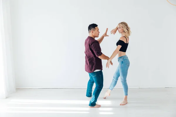 一个男人和一个女人在一间白色的房间里伴着一对八方块舞的音乐跳舞 — 图库照片