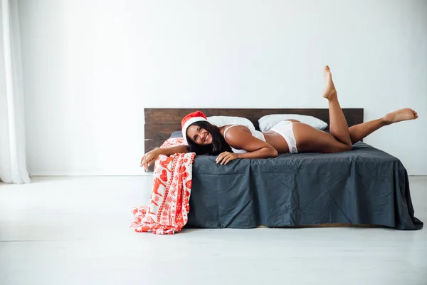 Mulher em lingerie encontra-se na cama de Natal ano novo — Fotografia de Stock