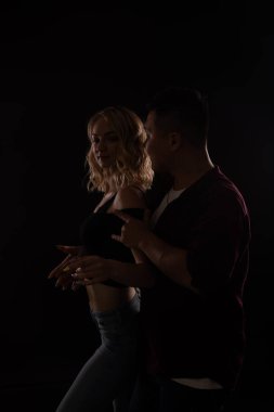 Bir adam ve bir kadın diskonun karanlığında müzik eşliğinde dans ediyorlar.