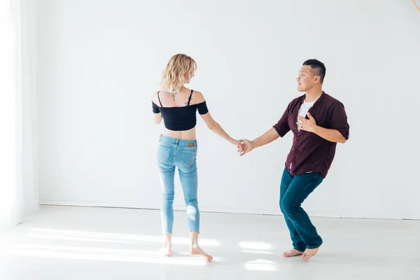 一个男人和一个女人在一间白色的房间里伴着一对八方块舞的音乐跳舞 — 图库照片