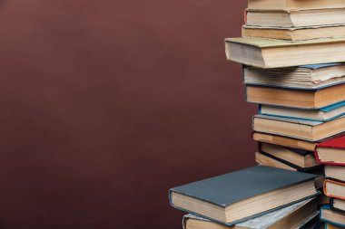 Üniversite kütüphanesinde kahverengi arka plan üzerine çalışmak için bir sürü kitap var.