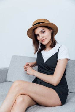 Gri bir ofis kanepesinde güzel bir genç kadın.