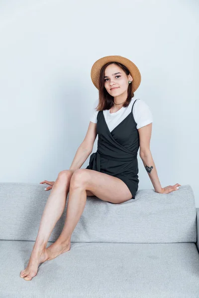 Piękna młoda kobieta na szarej kanapie biurowej — Zdjęcie stockowe
