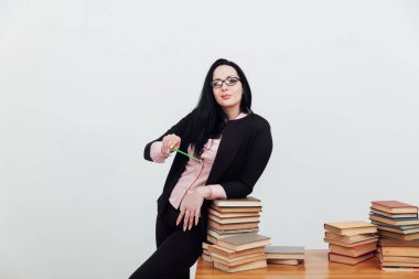 Masadaki bayan öğretmen, üniversitede okumak için kitaplarla birlikte.