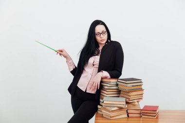 Masadaki bayan öğretmen, üniversitede okumak için kitaplarla birlikte.