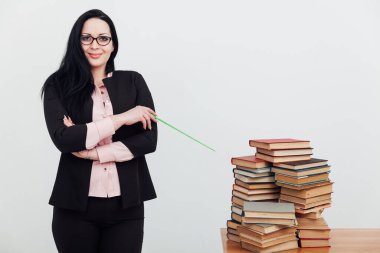 Masadaki bayan öğretmen, üniversitede okumak için kitaplarla birlikte.