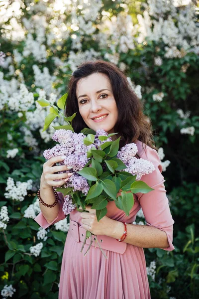 Bela mulher morena em um vestido com flores lilás — Fotografia de Stock