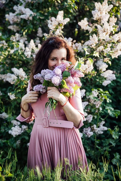 Bela mulher morena em um vestido com flores lilás — Fotografia de Stock