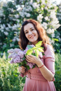 Leylak çiçekli güzel esmer kadın.