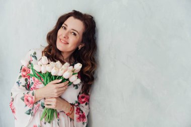 Güzel esmer kadın 40 yaşında, çiçekli bir elbise içinde.