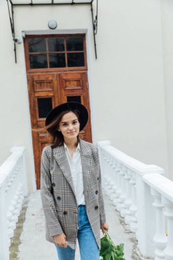 Güzel bir kadın ayçiçeği çiçekleri ile şehirde dolaşıyor.