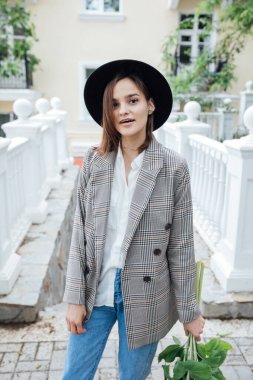 Güzel bir kadın ayçiçeği çiçekleri ile şehirde dolaşıyor.