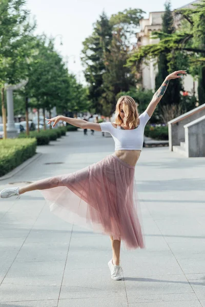 Güzel sarışın kadın dışarıda müzik eşliğinde dans ediyor. — Stok fotoğraf