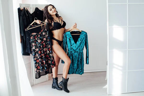 Vacker kvinna brunett i underkläder garderob kläder framför spegeln — Stockfoto